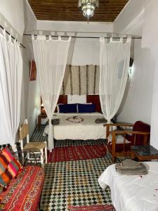非斯Riad Dar Iman的一间卧室配有两张床、窗帘和沙发