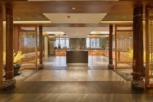 a lobby with wooden columns and a counter in a building at 品缦芸酒店长沙高铁南站沙湾公园地铁站店 in Changsha +67 photos