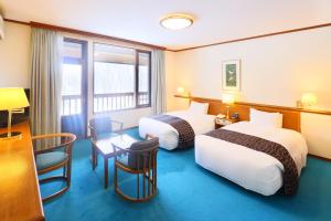a hotel room with two beds and a table at Hakkoda Hotel in Aomori +56 photos