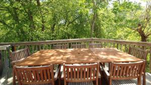 une table et des chaises en bois sur une terrasse avec des arbres dans l'établissement The Lily Pad, à Cape May Point
