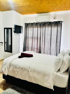 ein Schlafzimmer mit einem weißen Bett und einem Fenster in der Unterkunft BTV Holiday Home in Hazyview