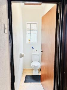 ein Badezimmer mit Toilette und Fenster in der Unterkunft BTV Holiday Home in Hazyview + 3 Fotos