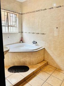 ein Badezimmer mit Badewanne und Fenster in der Unterkunft BTV Holiday Home in Hazyview