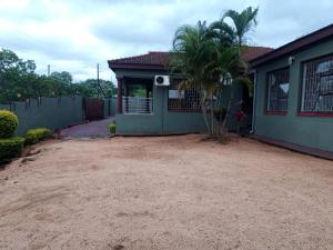 a house with a palm tree in front of it at BTV Villa in Hazyview