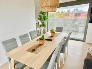 Una mesa de comedor con sillas y una gran ventana. en Luxury Stylish Penthouse with Free Parking, en Viena