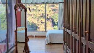 a bedroom with a bed and a large window at Casa de Campo Petit Lodge in Estancia Grande