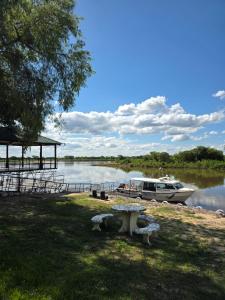 ein Boot, das an einem Steg mit einem Picknicktisch festgemacht hat. in der Unterkunft Cabañas Lodge Angirú in Goya