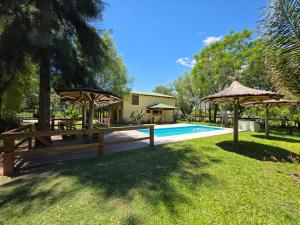 a backyard with a swimming pool and umbrellas at Cabañas Lodge Angirú in Goya
