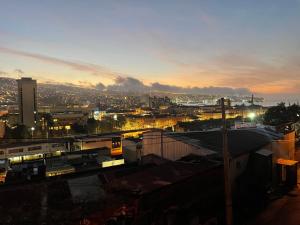 a city skyline with a train station at sunset at Habitación donde Max in Valparaíso