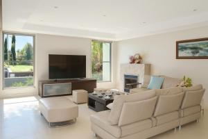 a living room with a couch and a flat screen tv at Salt & Serenity - The Peninsula Retreat in Cronulla