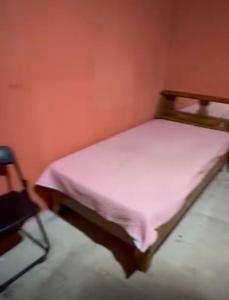 a small bed in a room with a pink sheet at Camping y hospedaje playa azul in Tarcoles