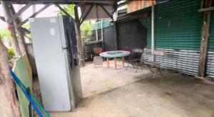 a refrigerator and a table and chairs in a garage at Camping y hospedaje playa azul in Tarcoles +3 photos
