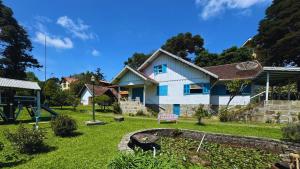 a house with a yard with a playground at Casa Rara em Gramado, ideal para Famílias e Grandes Grupos de Viagens, com uma ampla área verde in Gramado