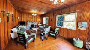 a living room with wood paneling and a couch and chairs at Casa Rara em Gramado, ideal para Famílias e Grandes Grupos de Viagens, com uma ampla área verde in Gramado
