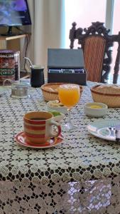 a table with a cup and a glass of orange juice at Casa de Campo Petit Lodge in Estancia Grande