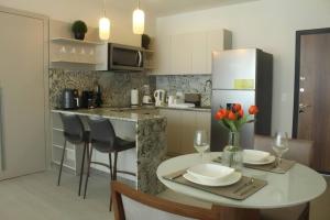 a kitchen with a table and a white refrigerator at Bright & Airy Ocean View Studio in Costa del Este in Panama City