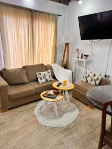 a living room with a couch and a table at Casa de dos dormitorios en villa adela a 10 minutos del centro para 7 personas se aceptan mascotas in Concordia