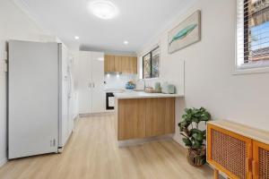 a kitchen with white walls and a white refrigerator at Marlin Manor Pet Friendly Home 600m to Beach in Chinderah +19 photos