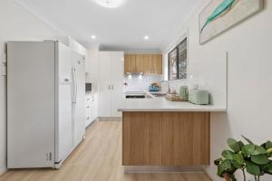 a kitchen with white appliances and a large refrigerator at Marlin Manor Pet Friendly Home 600m to Beach in Chinderah