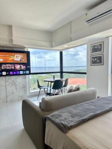 a bedroom with a couch and a table and a tv at Tropical Executive Flat in Manaus +8 photos