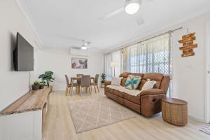 a living room with a couch and a table at Marlin Manor Pet Friendly Home 600m to Beach in Chinderah