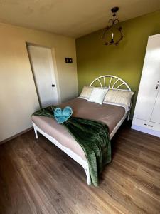 Un dormitorio con una cama con un lazo azul. en CHAKIÑAN Hospedaje y Eventos OFICIAL, en Tumbaco 1 foto más