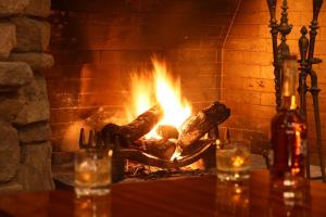 a brick fireplace with a fire in it at Hakkoda Hotel in Aomori