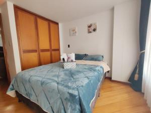 a bedroom with a bed with a blue blanket at Aparta-estudio INTELIGENTE en zona norte, cerca de UPTC, Unicentro y Viva Tunja in Tunja