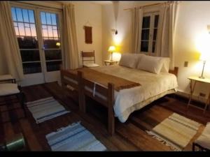 a bedroom with a large bed and two windows at Hostel 566 in La Serena