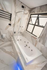 a bathroom with a tub and a window at Flat -Hidromassagem privativa e Piscina a 500 mts da praia in São Vicente