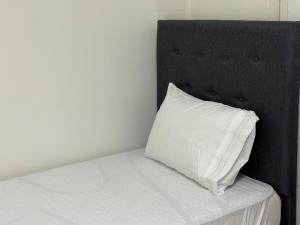 a white pillow sitting on top of a bed at Alojamiento para 12 personas a pasos del Estadio Defensores del Chaco in Asuncion