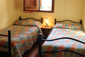 dwa łóżka siedzące obok siebie w pokoju w obiekcie Villa Mediterraneo w mieście Chia
