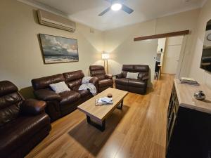 a living room with leather couches and a coffee table at Neat & Tidy Family Home with Beautiful Back Yard in Angaston