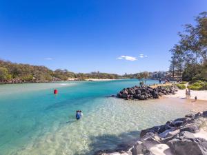 a person standing in the water at a beach at Marlin Manor Pet Friendly Home 600m to Beach in Chinderah