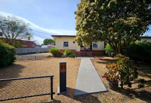 a house with a sign in the middle of a yard at Neat & Tidy Family Home with Beautiful Back Yard in Angaston