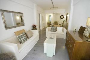 a living room with two white couches and a table at PUNTA MOGOTES Hermosa vista almar in Mar del Plata