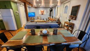 a dining room with a table and a living room at L'Ancestrale spa, vue, salle d'arcades in La Malbaie