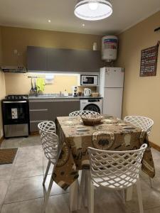 a kitchen with a table and chairs and a kitchen with a refrigerator at Modern apartment in Azul, comfort and style with patio in Azul