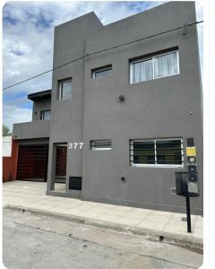 a gray building with a parking meter in front of it at Modern apartment in Azul, comfort and style with patio in Azul