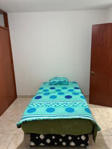 Bett in einem Zimmer mit blauer Decke in der Unterkunft Datecsofts Headquarters in Los Baños del Inca