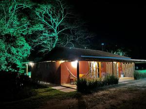 a small house with lights on the outside at night at Sítio Santo Antonio - Chalé 02 com Ofurô in Jarinu