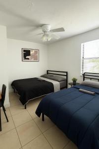 Un dormitorio con dos camas y un ventilador de techo. en Pacifica Fort Lauderdale Airport, en Dania Beach