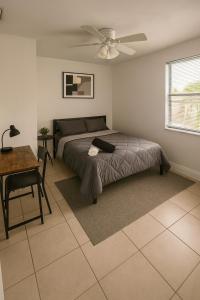 Un dormitorio con una cama y un ventilador de techo. en Pacifica Fort Lauderdale Airport, en Dania Beach