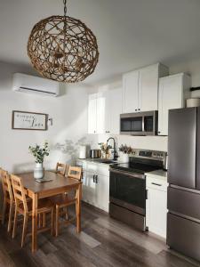 une cuisine avec des armoires blanches et une table avec des chaises dans l'établissement Saltline Studio, à Tillamook