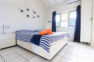 a bedroom with a bed with blue and white stripes at Aqualife Best view apartment in Willemstad +18 photos
