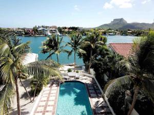 a view of a resort with a pool and palm trees at Aqualife Best view apartment in Willemstad