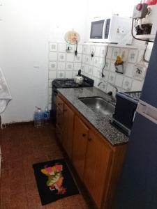a small kitchen with a sink and a stove at Departemento Garay in San Bernardo
