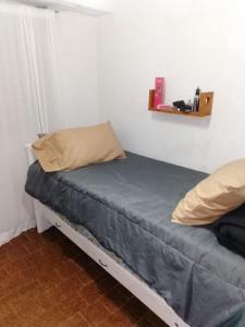 a bed in a room with a blue sheet and pillows at Departemento Garay in San Bernardo