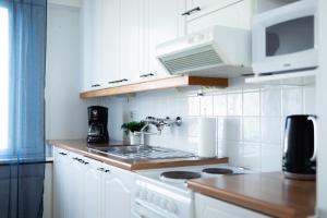 a white kitchen with a stove and a microwave at 3-Room Central Railway station in Oulu