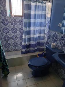 a bathroom with a blue toilet and a sink at Jardín de Los Sueños Quinta San Felipe in Antigua Guatemala